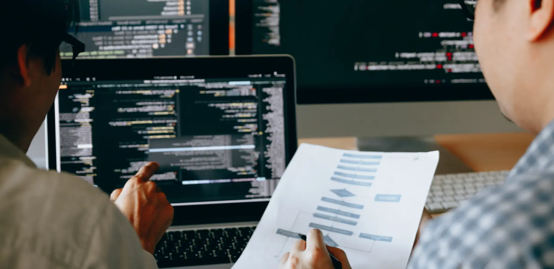 エンジニア2人がコードを見ながら話し合っている様子